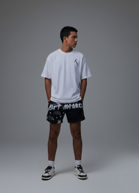 Person wearing a white t-shirt and black shorts with white text on a gray background