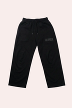Black sweatpants with a logo on a gray background