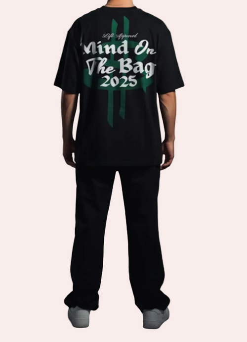 Person wearing a black t-shirt with text on the back against a gray background
