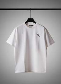 White t-shirt with a logo on a hanger against a gray background