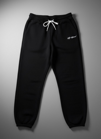 Black sweatpants with white drawstring and branding on a gray background