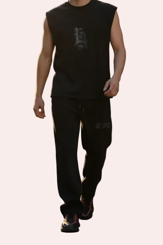 Man wearing a black sleeveless shirt and pants on a white background