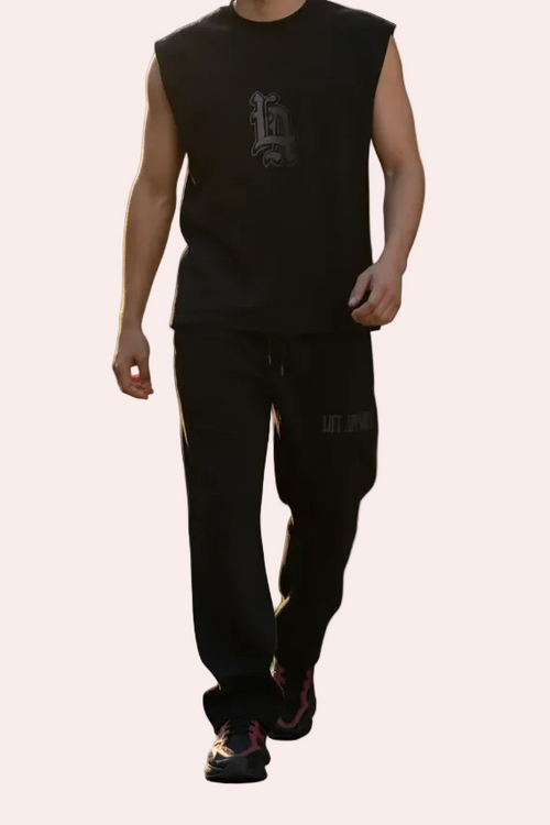 Man wearing a black sleeveless shirt and pants on a white background