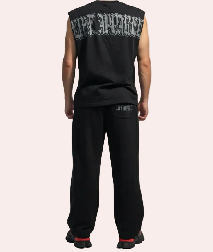 Person wearing a black sleeveless shirt with text on the back against a light gray background