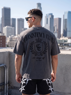 Man wearing a 'Consistency Club' t-shirt with a city skyline in the background