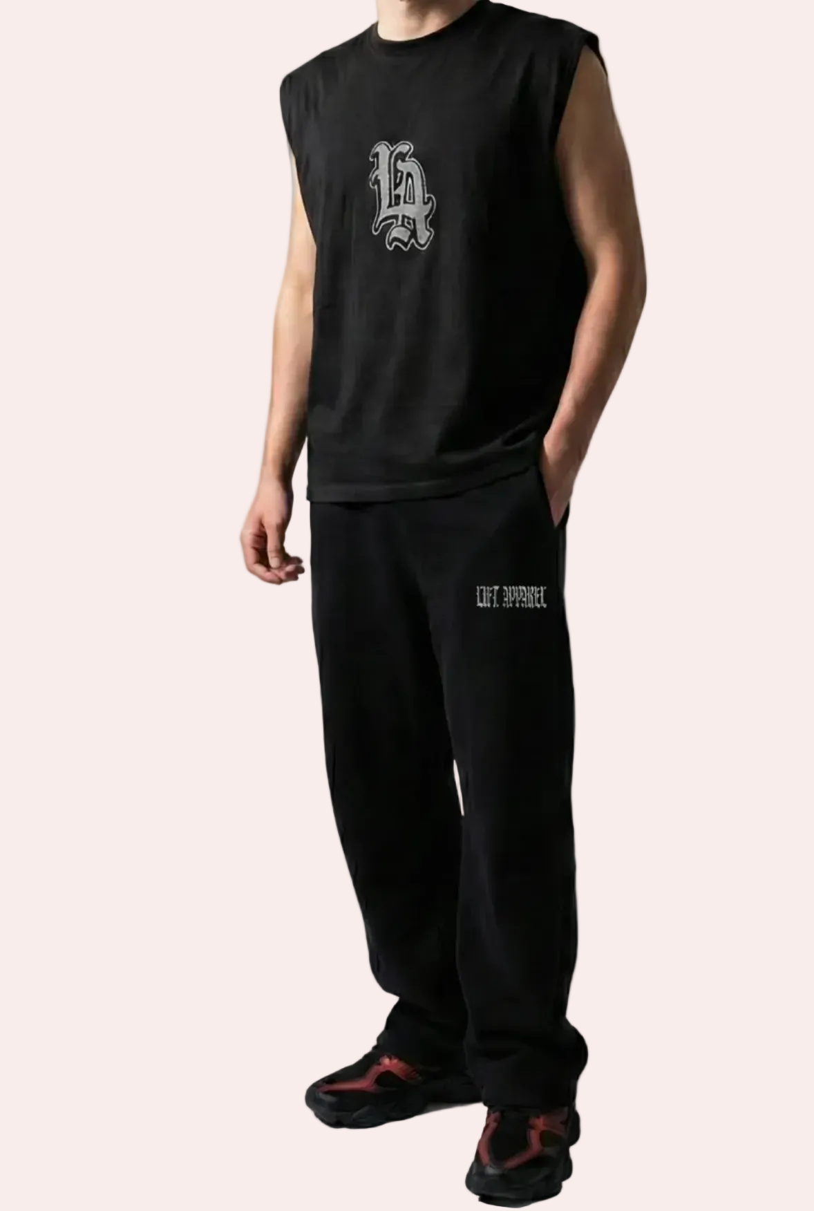 Person wearing a black sleeveless shirt and pants with logos on a white background