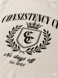 Beige tote bag with black text and logo, featuring 'Consistency Club' and 'No days off'.