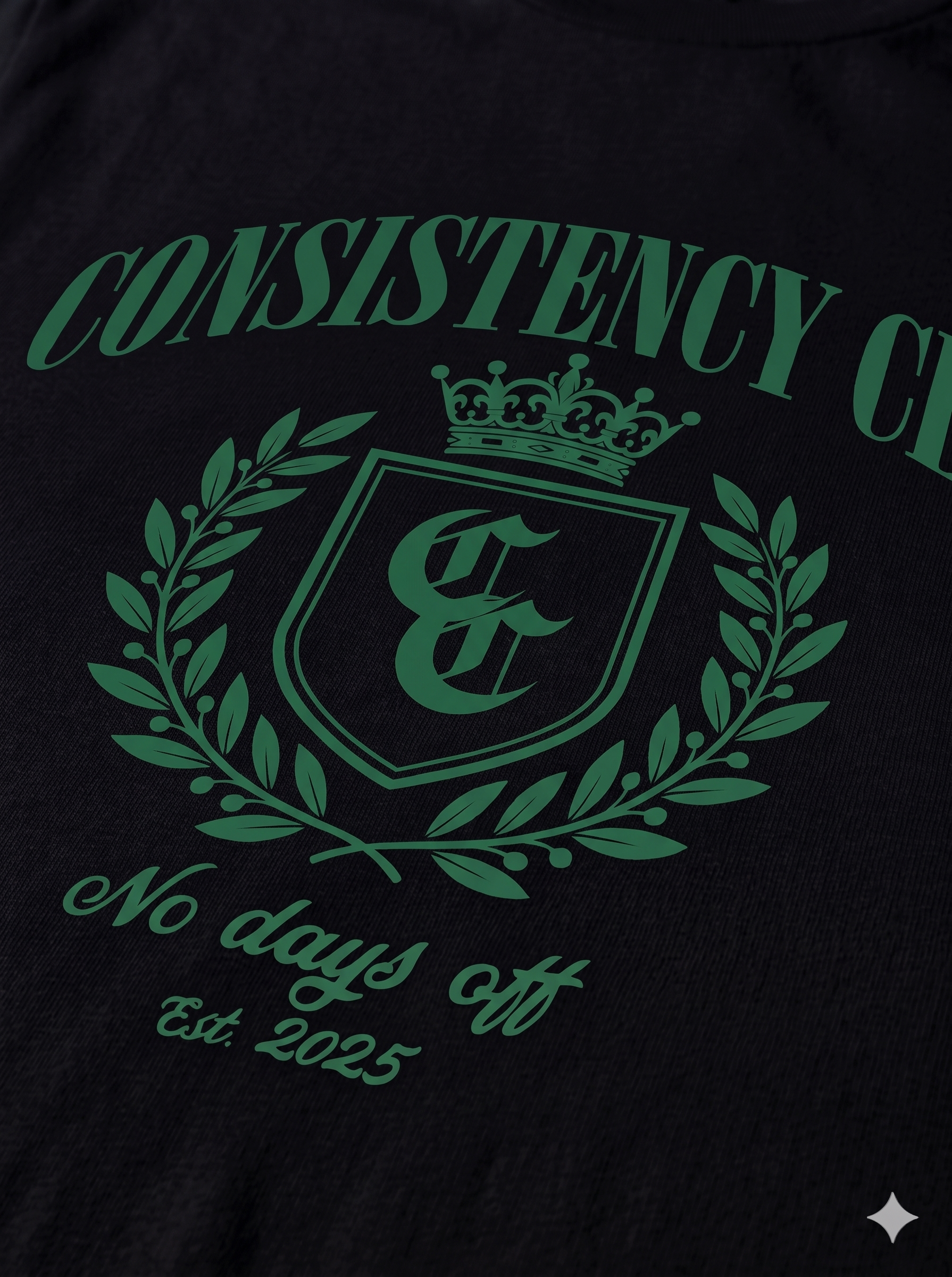 Black shirt with green 'Consistency Club' logo and text on a dark background