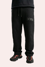 Person wearing black sweatpants with a brand logo on a white background