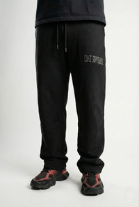 Person wearing black sweatpants with a brand logo on a white background