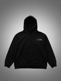Black hoodie with a small logo on the chest against a gray background