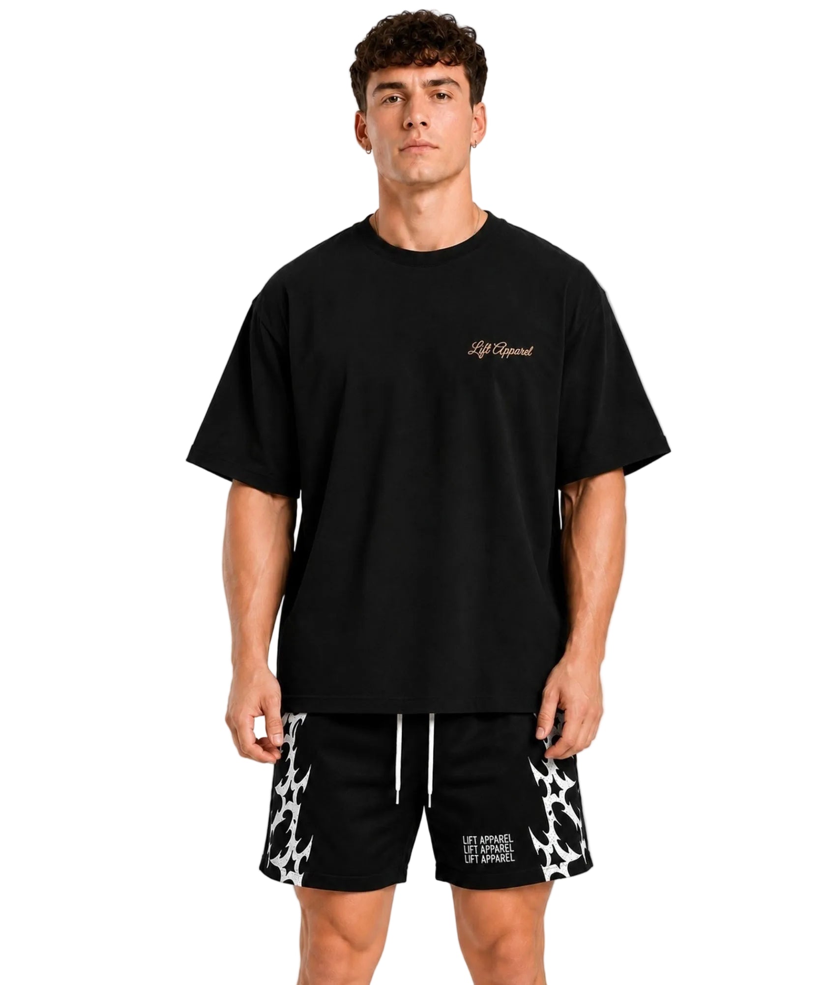Man wearing a black Pressure oversized gym tee with patterned training shorts, front view