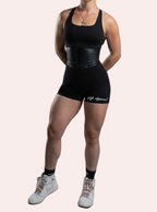 Person wearing a black athletic outfit with a gray background