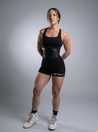 Person wearing a black athletic outfit with a gray background