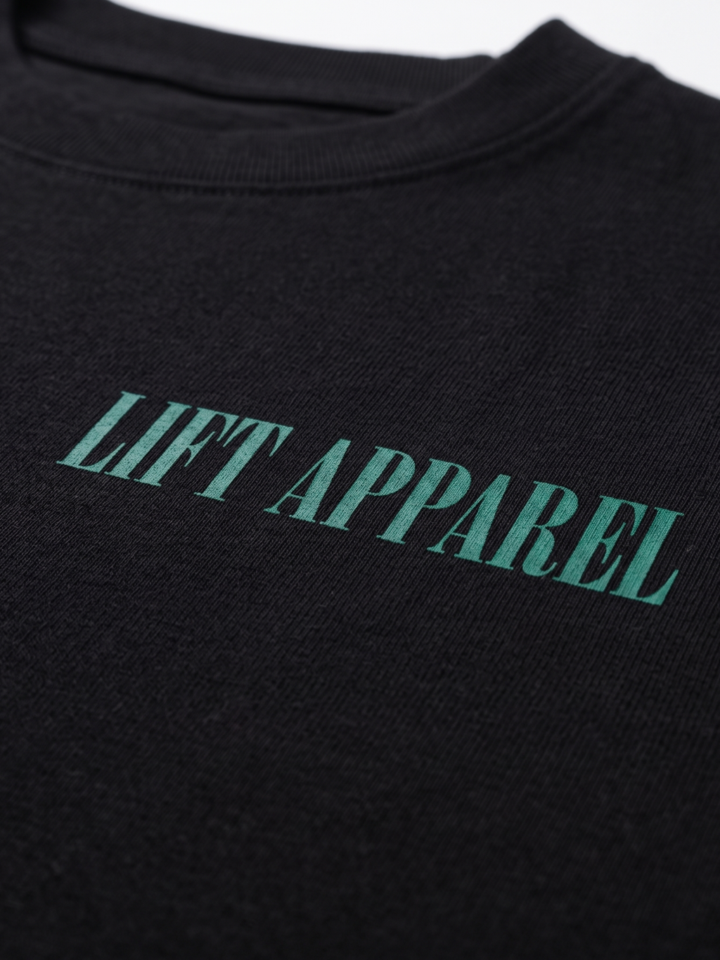 Black garment with 'LIFT APPAREL' printed in green on a white background