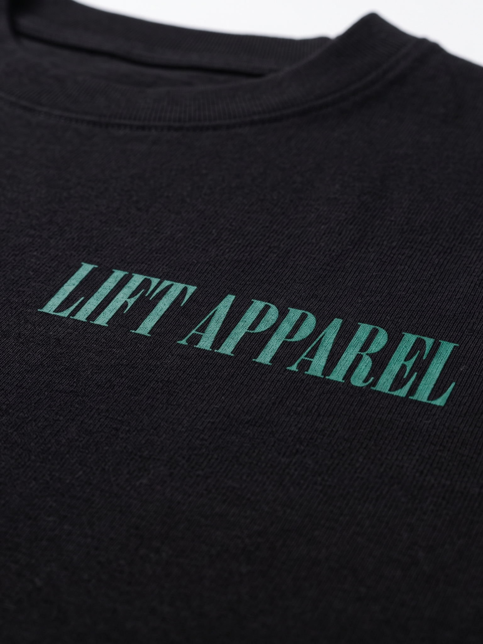 Black garment with 'LIFT APPAREL' printed in green on a white background