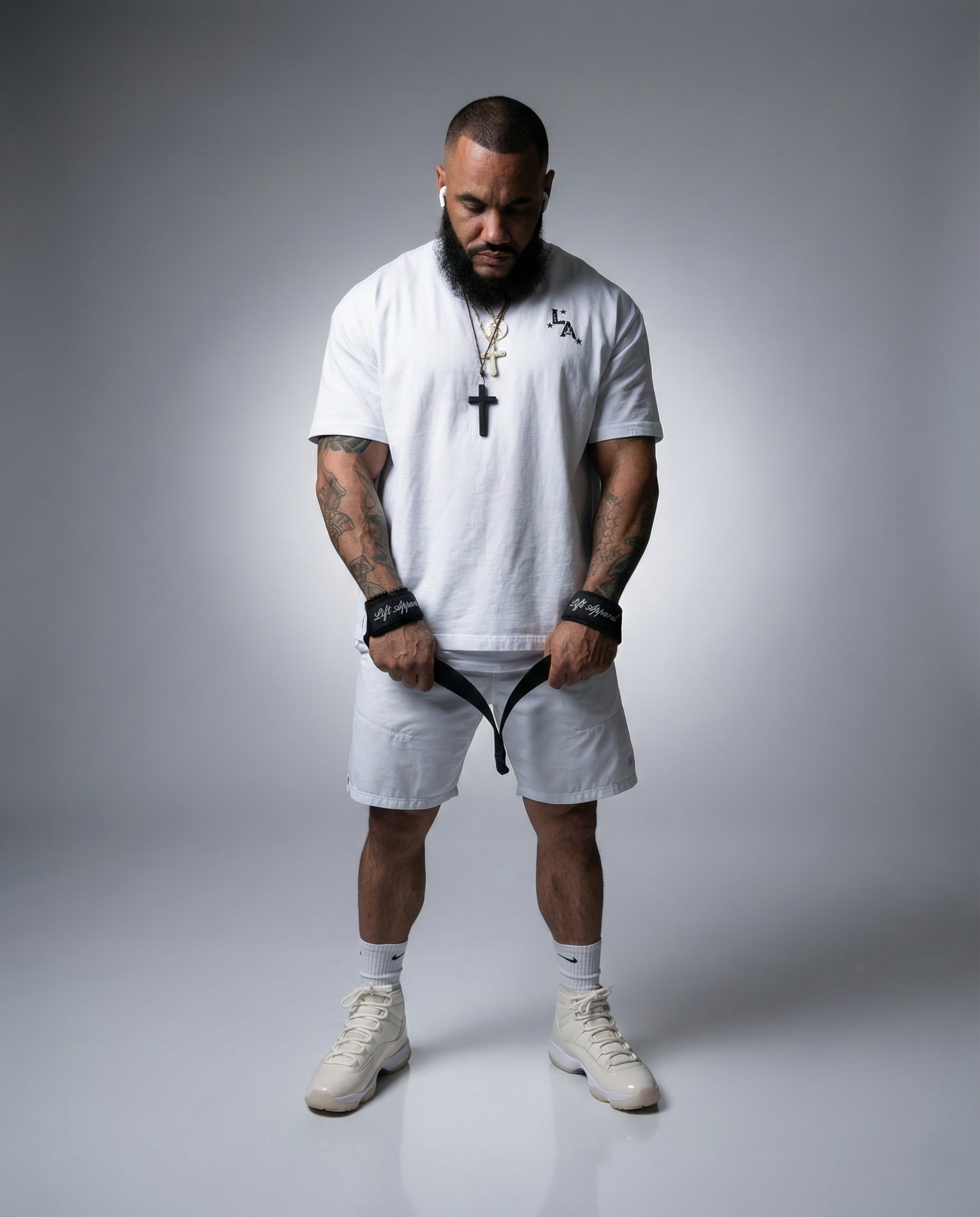 Man wearing a white t-shirt, shorts, and sneakers on a gray background