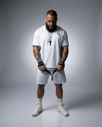 Man wearing a white t-shirt, shorts, and sneakers on a gray background